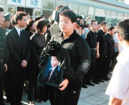 罗京的儿子罗疏桐抱着爸爸的遗像
